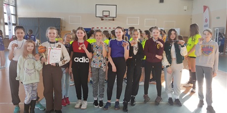 Powiększ grafikę: 11 uczennic Szkoły Podstawowej  nr 2  w Gdańsku ustawionych w szeregu prezentuje zdobyty puchar i medale. 
